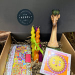 Box with colorful candles, a giraffe figurine, and a card with a sun design.